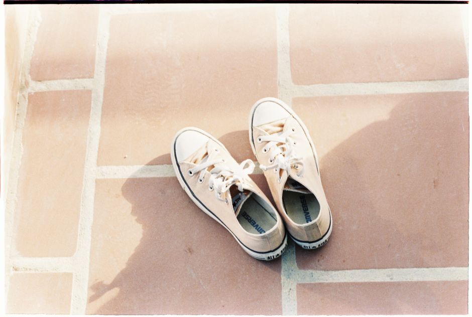 White sneakers on a sunny pavement, perfect for casual lifestyle themes.