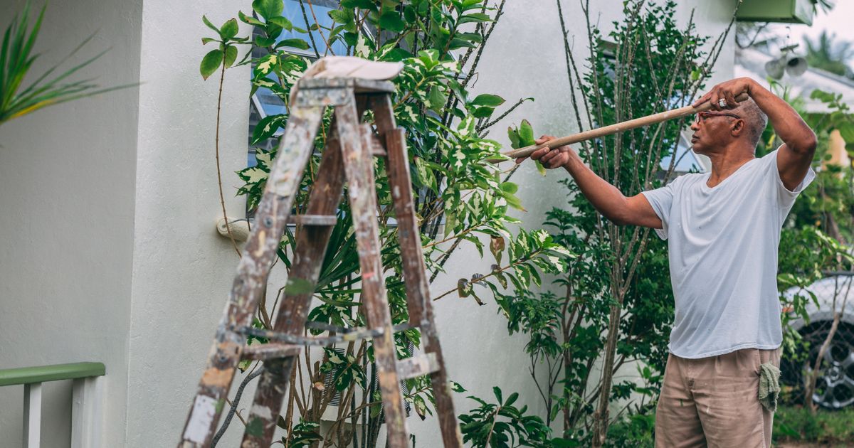 Pintores profesionales aplicando pintura en fachada exterior de vivienda en Mallorca