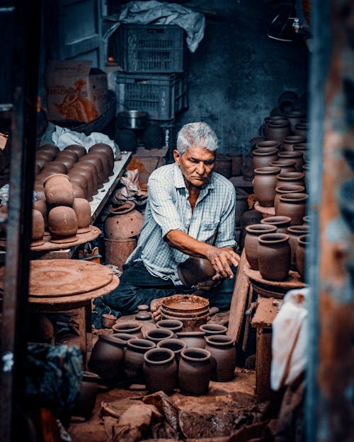 Potter Sitting and Working in Workshop