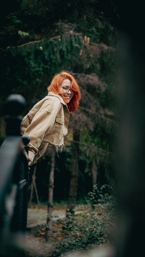 Free Young woman with red hair smiling in a lush park in Ankara, Türkiye. Stock Photo