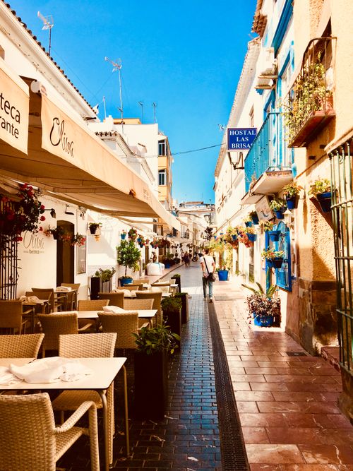 Free Beautiful street view of Estepona, Spain, featuring outdoor cafés and vibrant architecture. Stock Photo