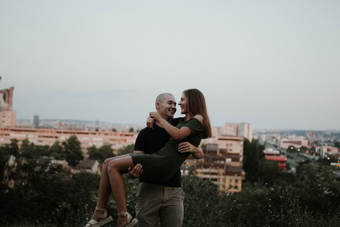 A couple enjoying a romantic moment overlooking a cityscape at dusk