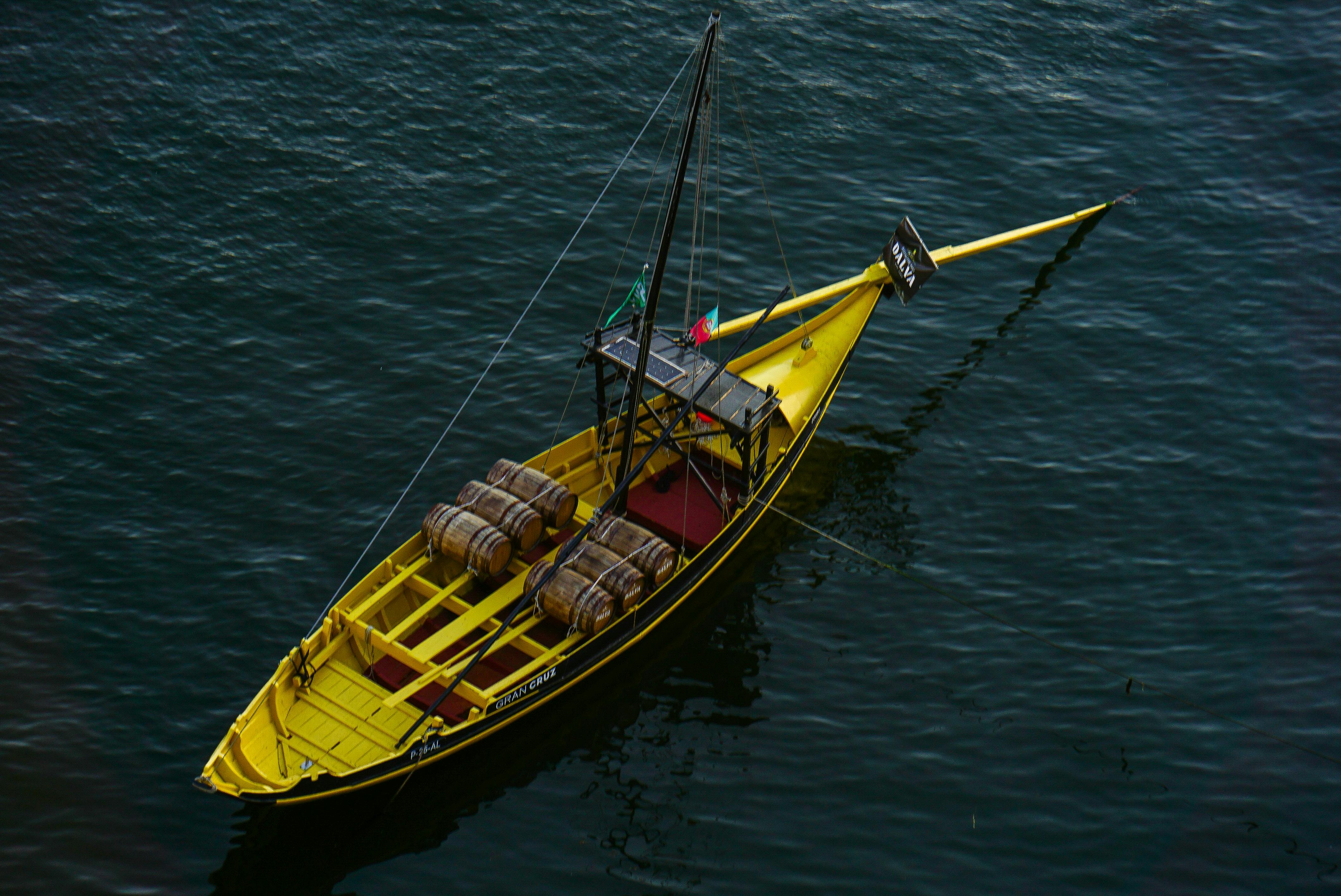 Yellow Boat with Barrels on Sea Free Stock Photo