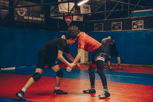 Free Teenage boys wrestle in a sports gym, showcasing athletic skills and sportsmanship. Stock Photo