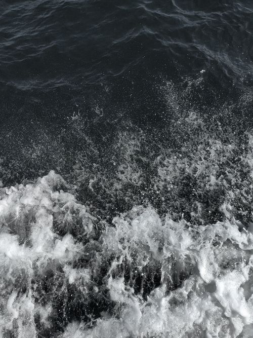 Free Aerial view of ocean waves splashing and creating foam with a dramatic texture and energy. Stock Photo