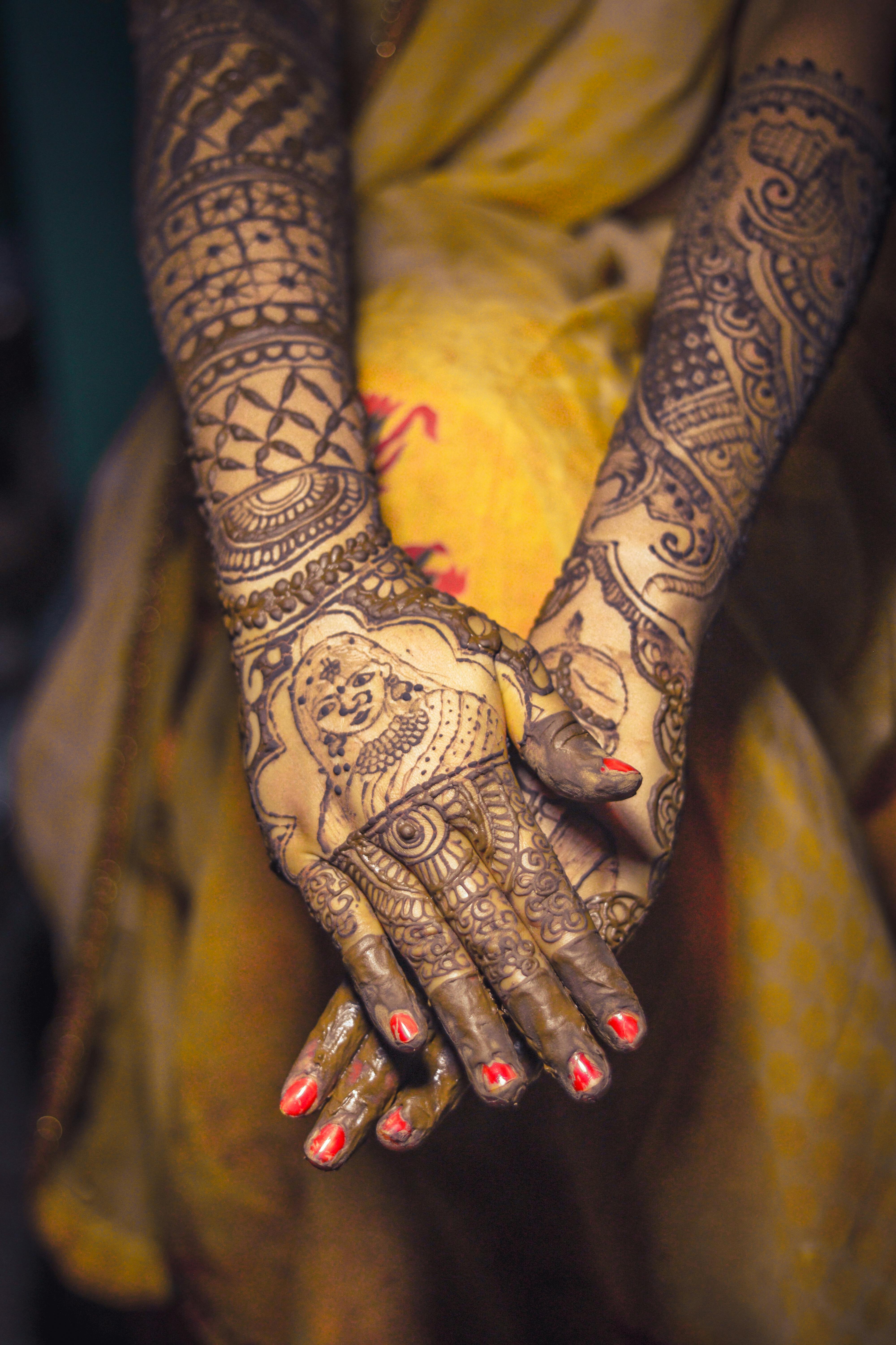 Photo of Bride and groom posing contrasting on mehendi