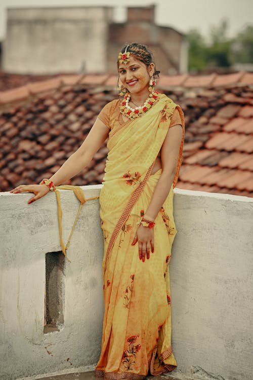 Young Woman in a Yellow Saree Dress Standing on a Terrace 