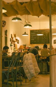 Warm and inviting café interior with patrons enjoying drinks under ambient lighting.