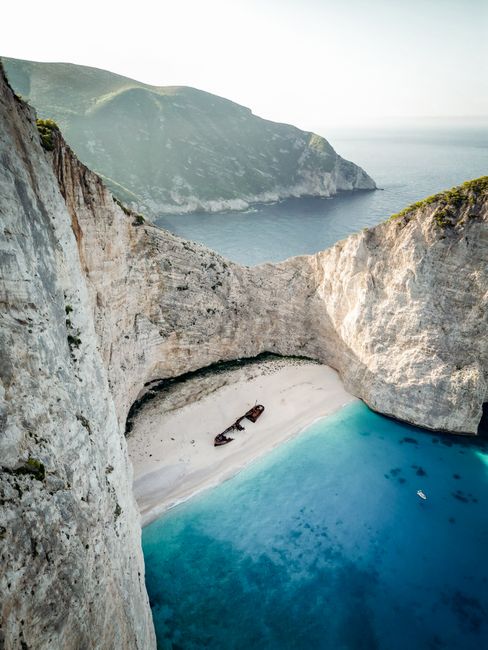 Stunning aerial shot of Navagio Beach's turquoise waters and cliffs on Zakynthos Island, Greece.