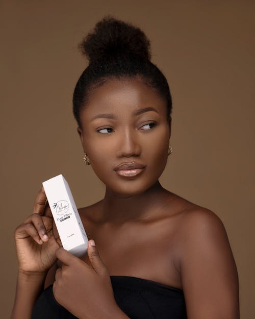 Portrait of an African Woman Holding Cosmetics 