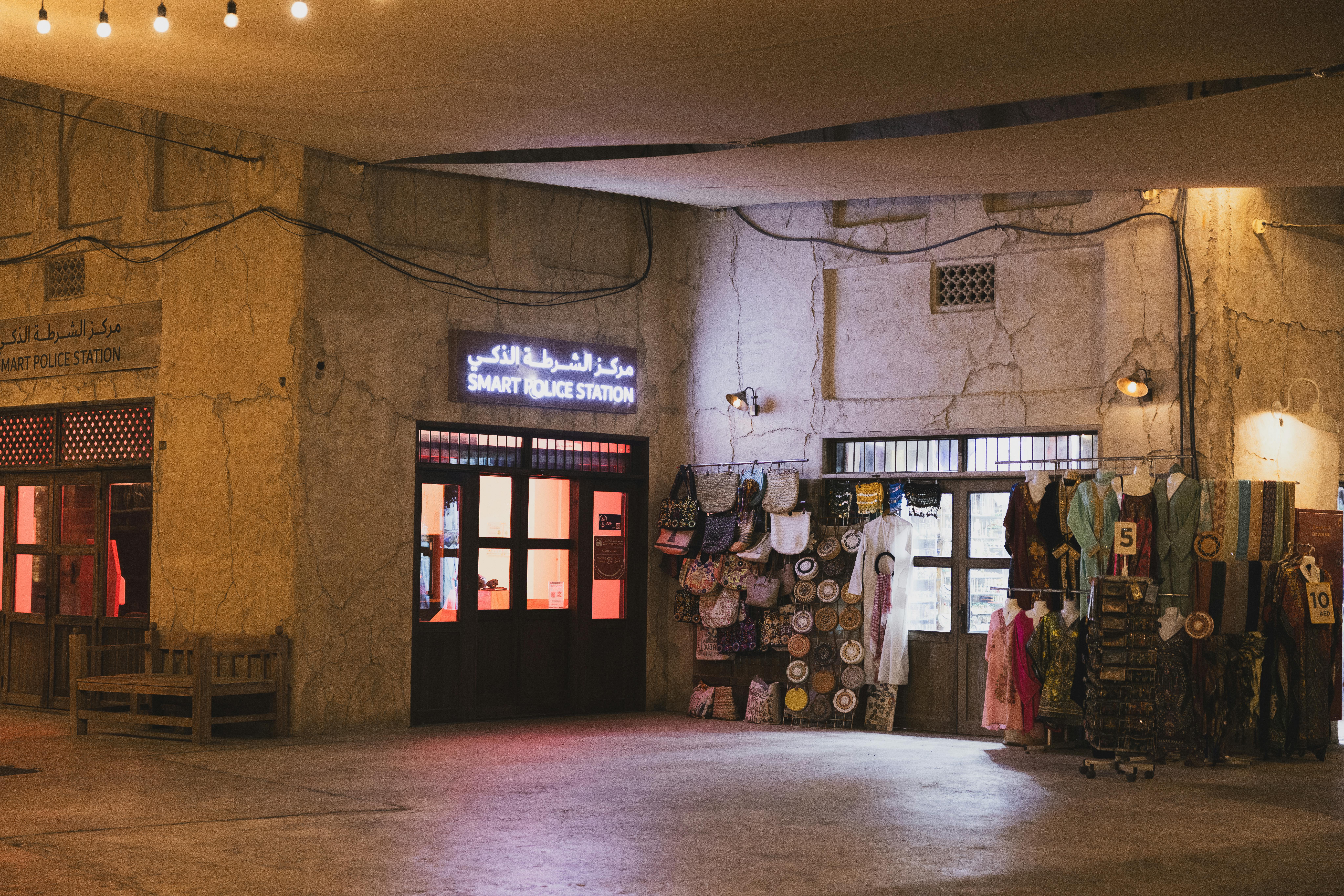 Illuminated Smart Police Station in Dubai's Al Seef district at night with traditional shops.