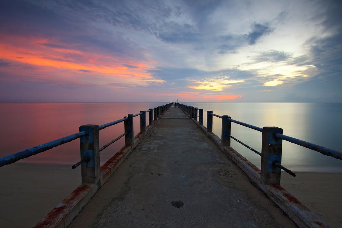 Wide Angle Photo of Bridge Dock on Body of Water