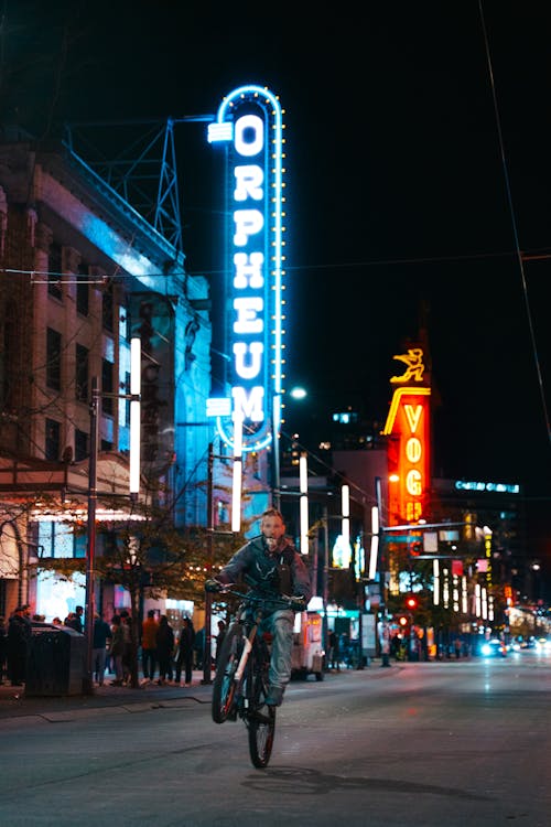 Man Riding on One Wheel on Bike on Street at Night