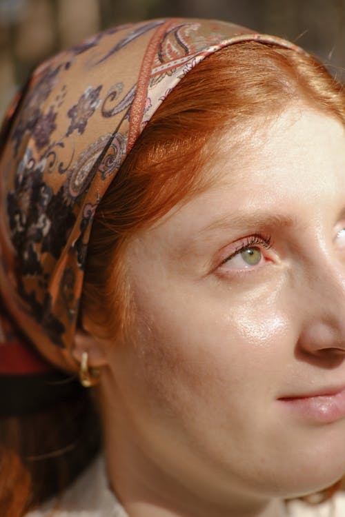 A woman with red hair and a head scarf