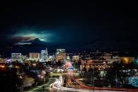 以灯光步道和明亮的天际线为背景，城市在夜间展现出充满活力的景观