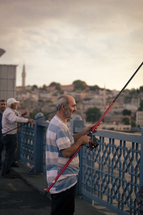 https://images.pexels.com/photos/19186849/pexels-photo-19186849/free-photo-of-men-with-fishing-rods-on-a-bridge-in-istanbul.jpeg?auto=compress&cs=tinysrgb&dpr=1&w=500