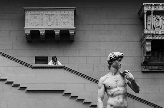 Monochrome urban scene featuring a statue and classical architecture.