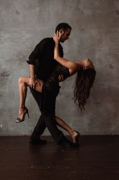 A couple gracefully performs a dramatic dance pose, showcasing the intensity and elegance of movement.