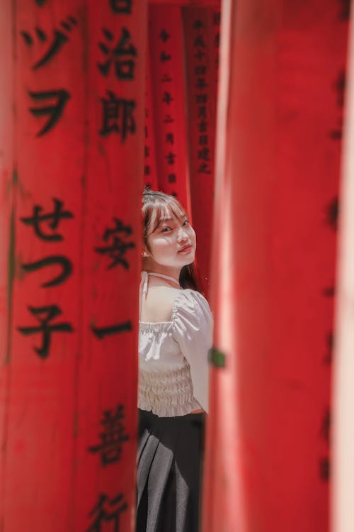 Woman Standing behind Red Walls with Writings