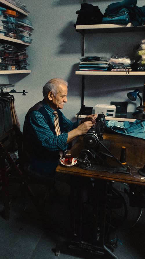 Free Elderly tailor working diligently at a sewing machine in a cozy workshop, Yozgat, Türkiye. Stock Photo