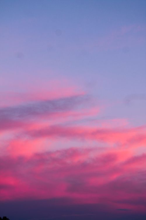 Free Beautiful pink clouds in a vibrant evening sky at sunset, offering a serene view. Stock Photo