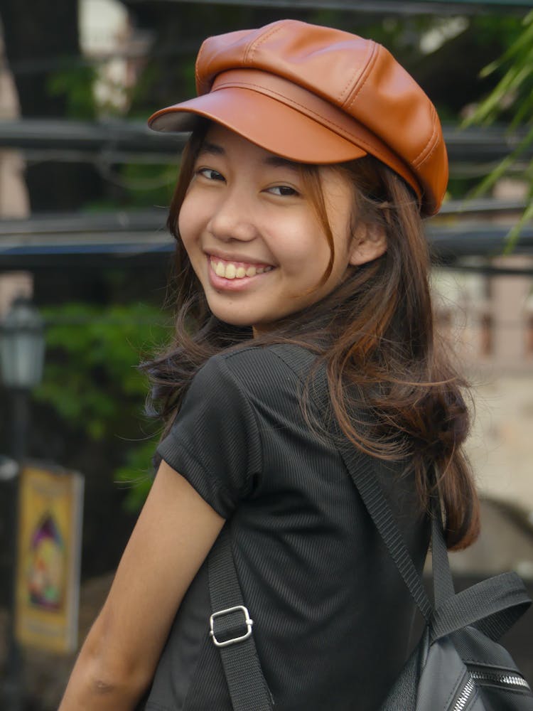 Smiling Teenager In Brown Leather Newsboy Cap