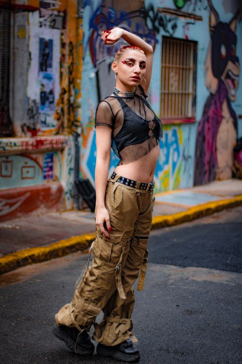 Free Fashionable young woman posing on graffiti-filled street in Buenos Aires, showcasing punk style amidst vibrant urban art. Stock Photo