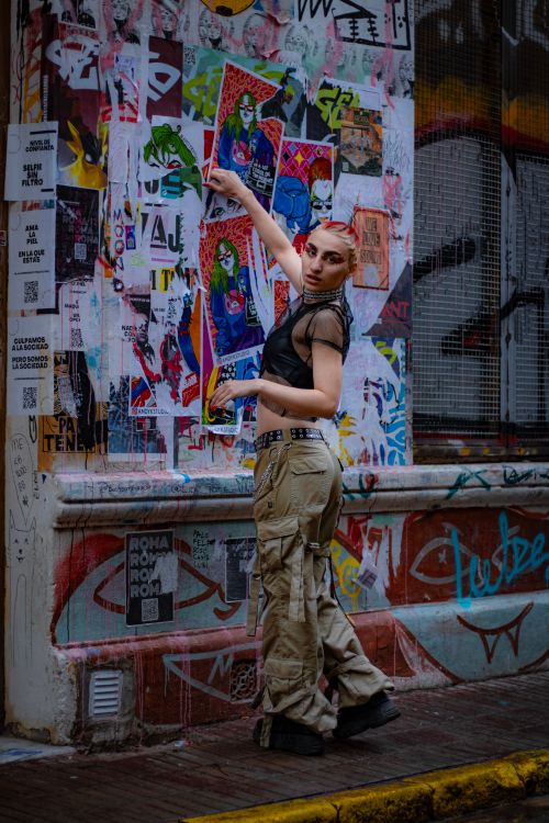 Free Stylish woman poses in front of colorful graffiti wall, showcasing urban fashion. Stock Photo