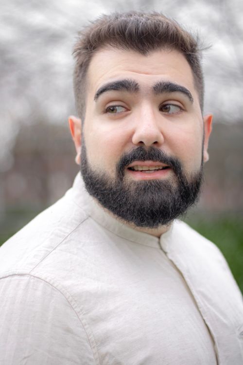Free Portrait of a bearded man in a light shirt outdoors, looking away. Stock Photo