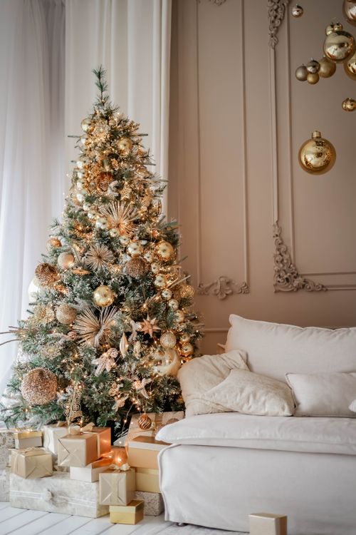 Free Luxurious living room featuring a lavishly decorated Christmas tree and gifts, perfect for holiday inspiration. Stock Photo