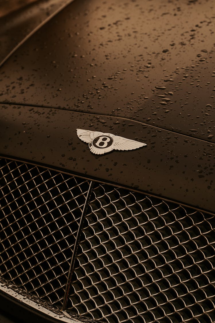 Close-up Of Bentley Logo With Raindrops On The Car 