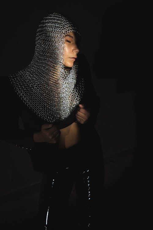 Woman Wearing a Chainmail Headpiece and Latex Pants 