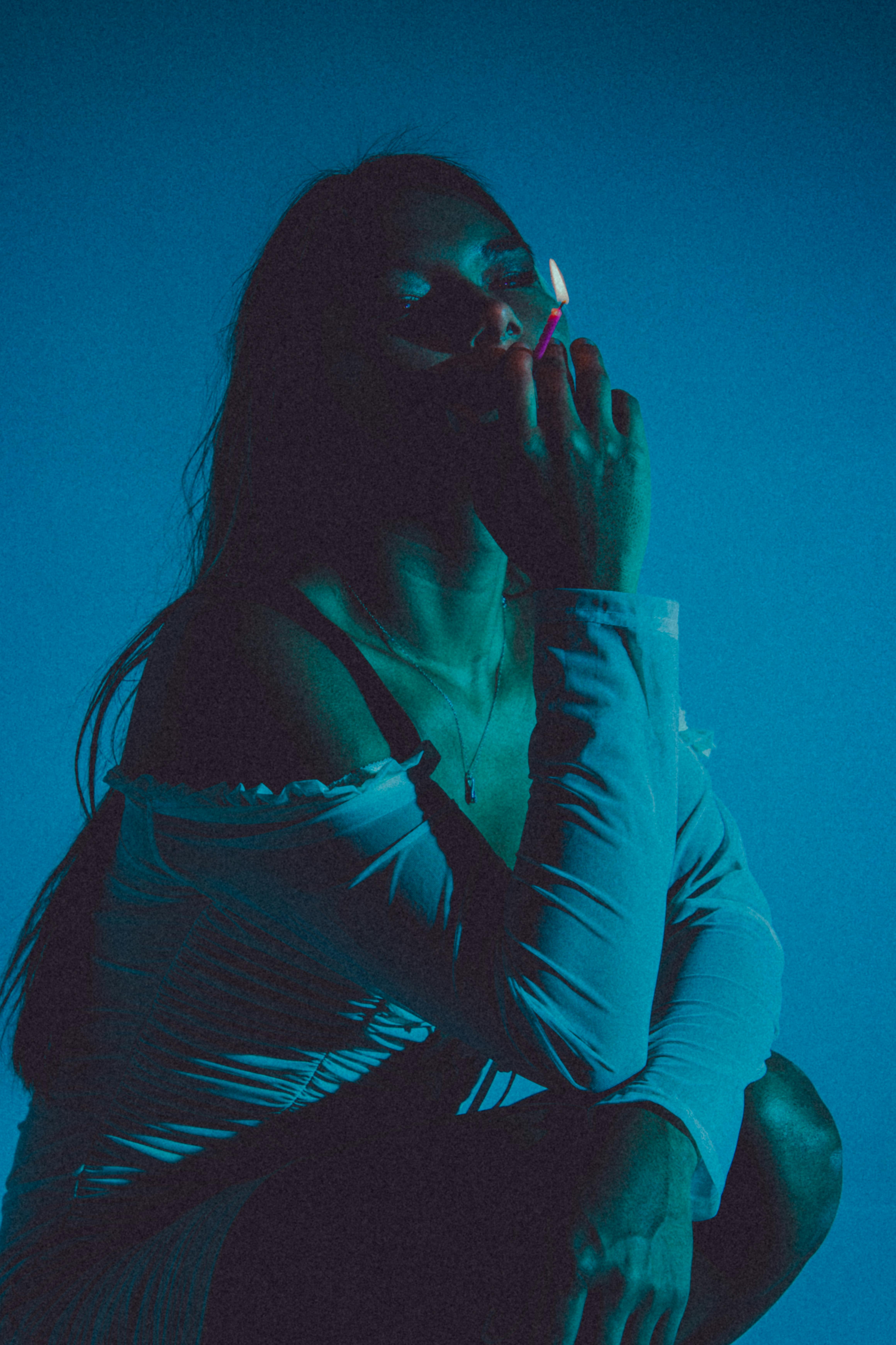 woman crouching and smoking a cigarette