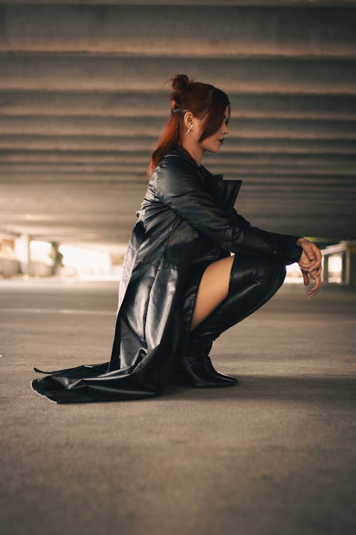 Woman Squatting in Black Coat