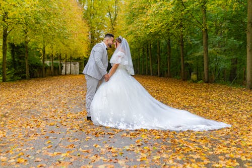 Newlyweds Holding Hands in Park in Autumn