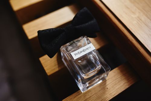 Free Stylish glass perfume bottle adorned with a black bow, offering a touch of luxury and elegance. Stock Photo