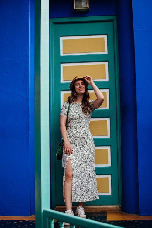 Woman Wearing Dress in Front of Green and Yellow Door