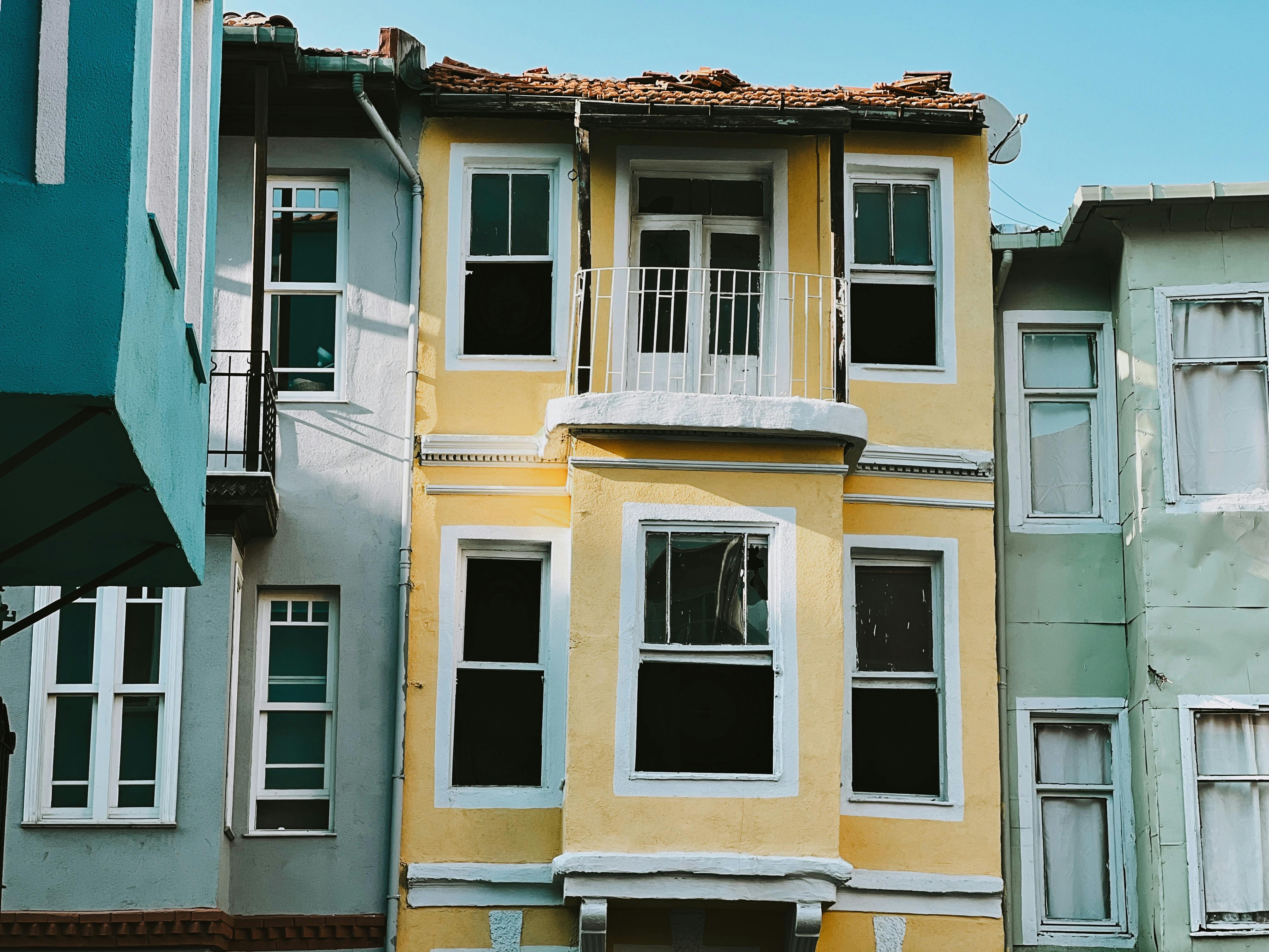 Vivid urban townhouse facades showcasing architectural diversity with balconies and windows in a vibrant city setting.