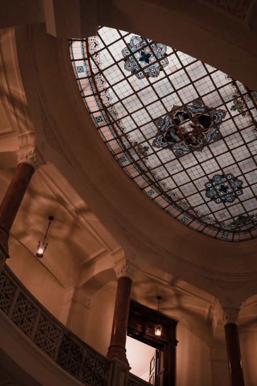 Free Interior view of a historic building in Ankara featuring an elaborate stained glass ceiling and columns. Stock Photo