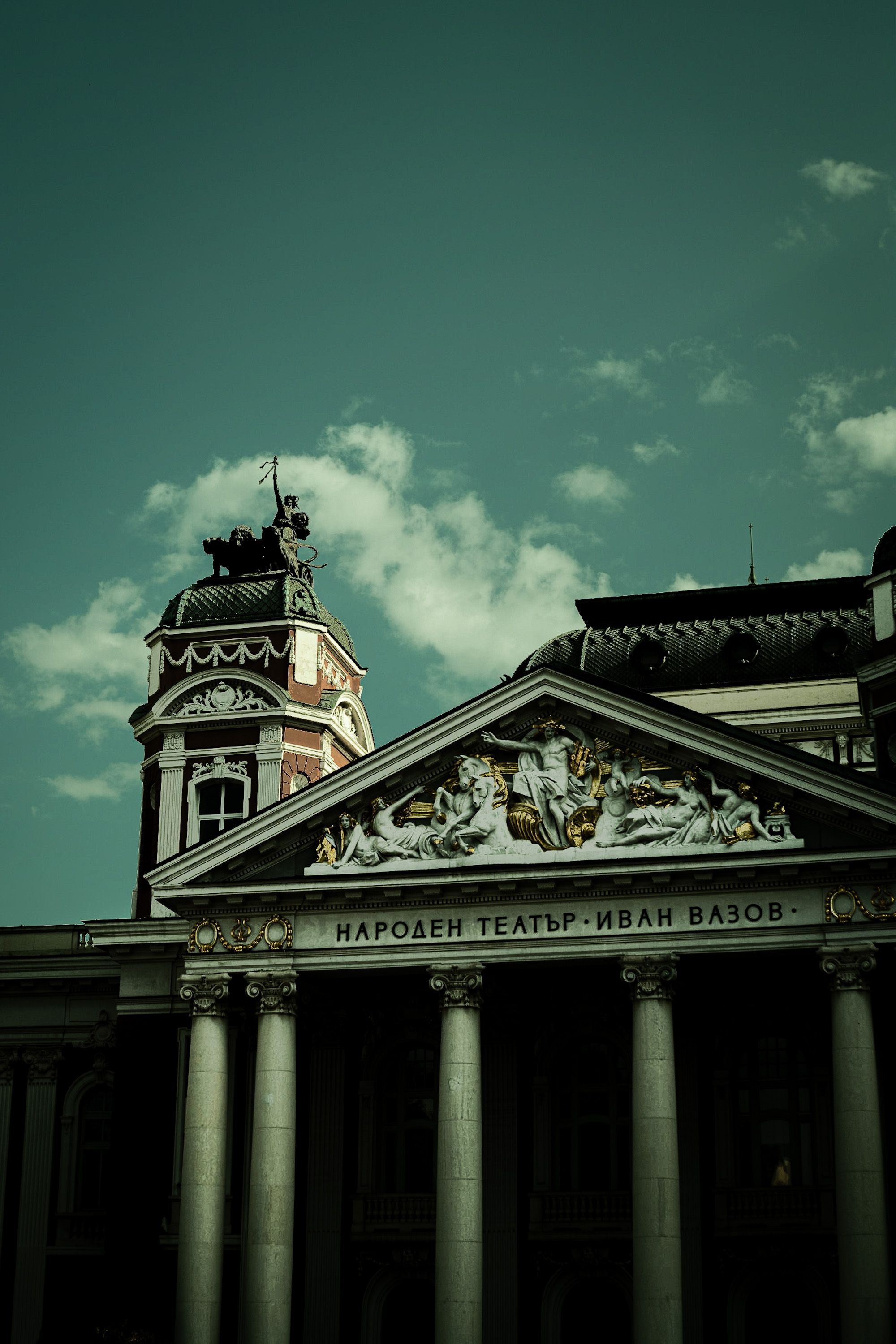 Impressive facade of the Ivan Vazov National Theatre in Sofia, Bulgaria, featuring ornate sculptures.