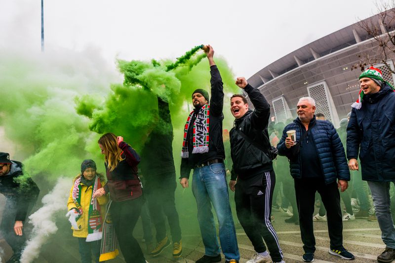 Fans lighting smoke flares outside a stadium
