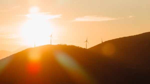 Wind Turbines and Hill Silhouette at Sunset · Free Stock Photo