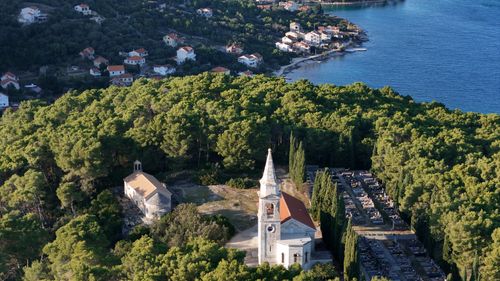 Free Aerial shot of a church surrounded by forest near the Croatian coastline. Stock Photo