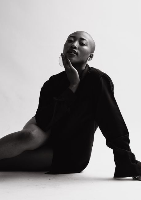 Striking black and white portrait of a confident woman posing in a studio setting.
