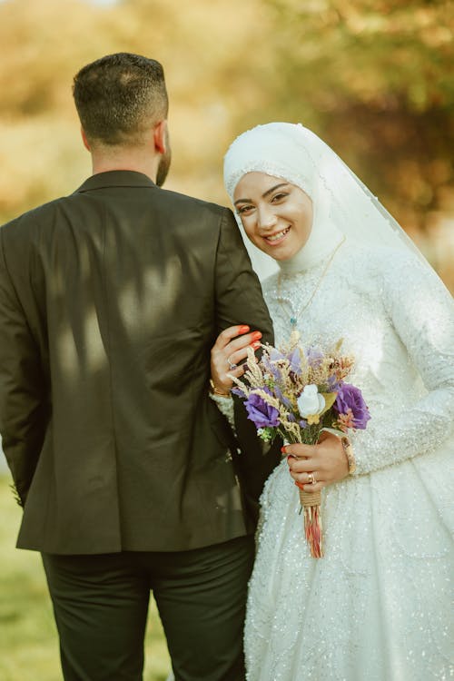 Bride Holding onto the Grooms Arm and Smiling 