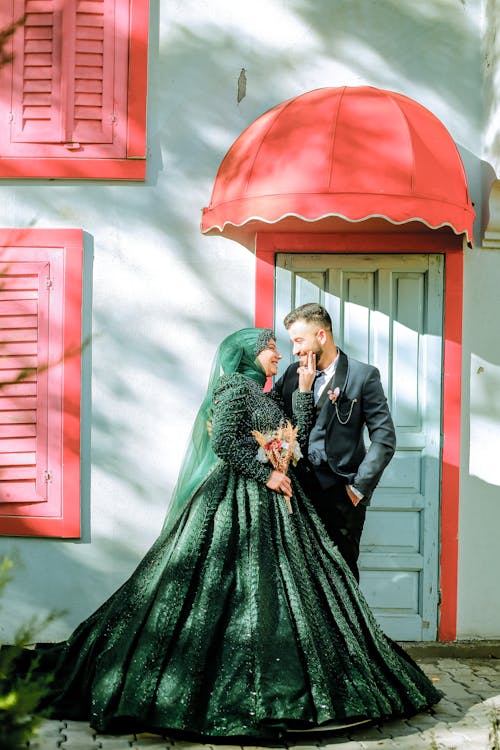 Bride and Groom Standing in front of a Building and Smiling 