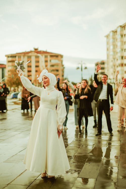 Free Smiling Bride in Hijab Standing with People behind Stock Photo