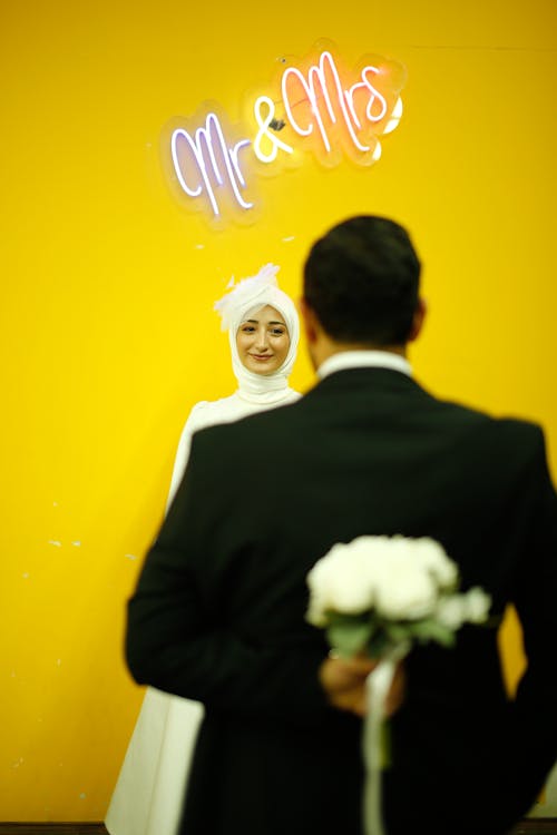 Man in Suit Standing with Woman in Wedding Dress behind