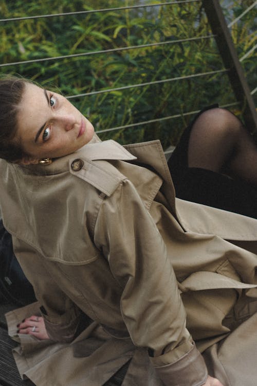 Woman Sitting in Trench Coat