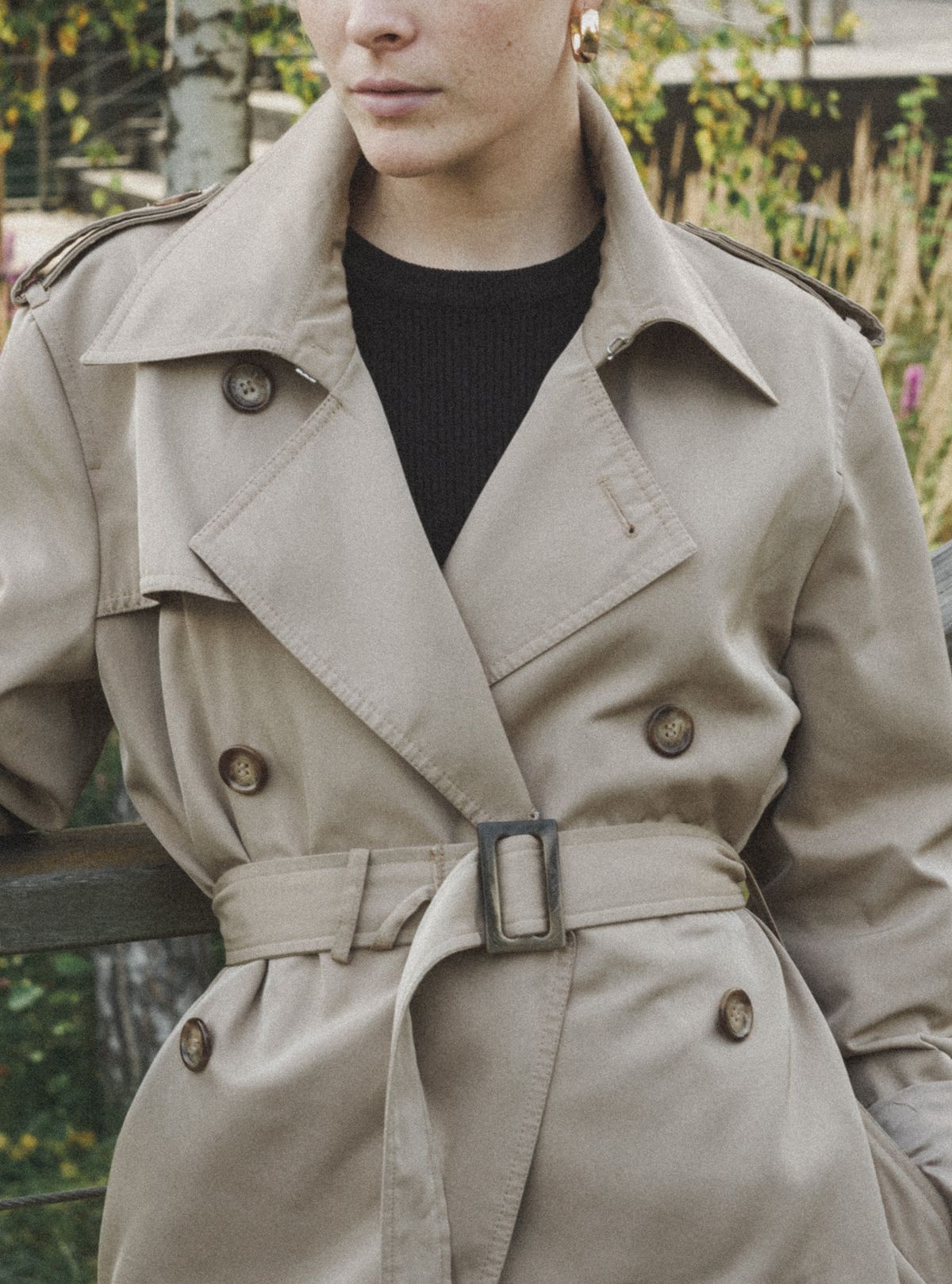 Close-up of a trench coat belt cinched at the waist to define curves on a plus size figure Close-up of a trench coat belt cinched at the waist to define curves on a plus size figure